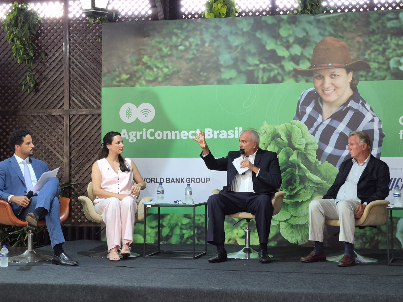 Imagem mostra quatro pessoas, uma mulher e três homens sentados em debate