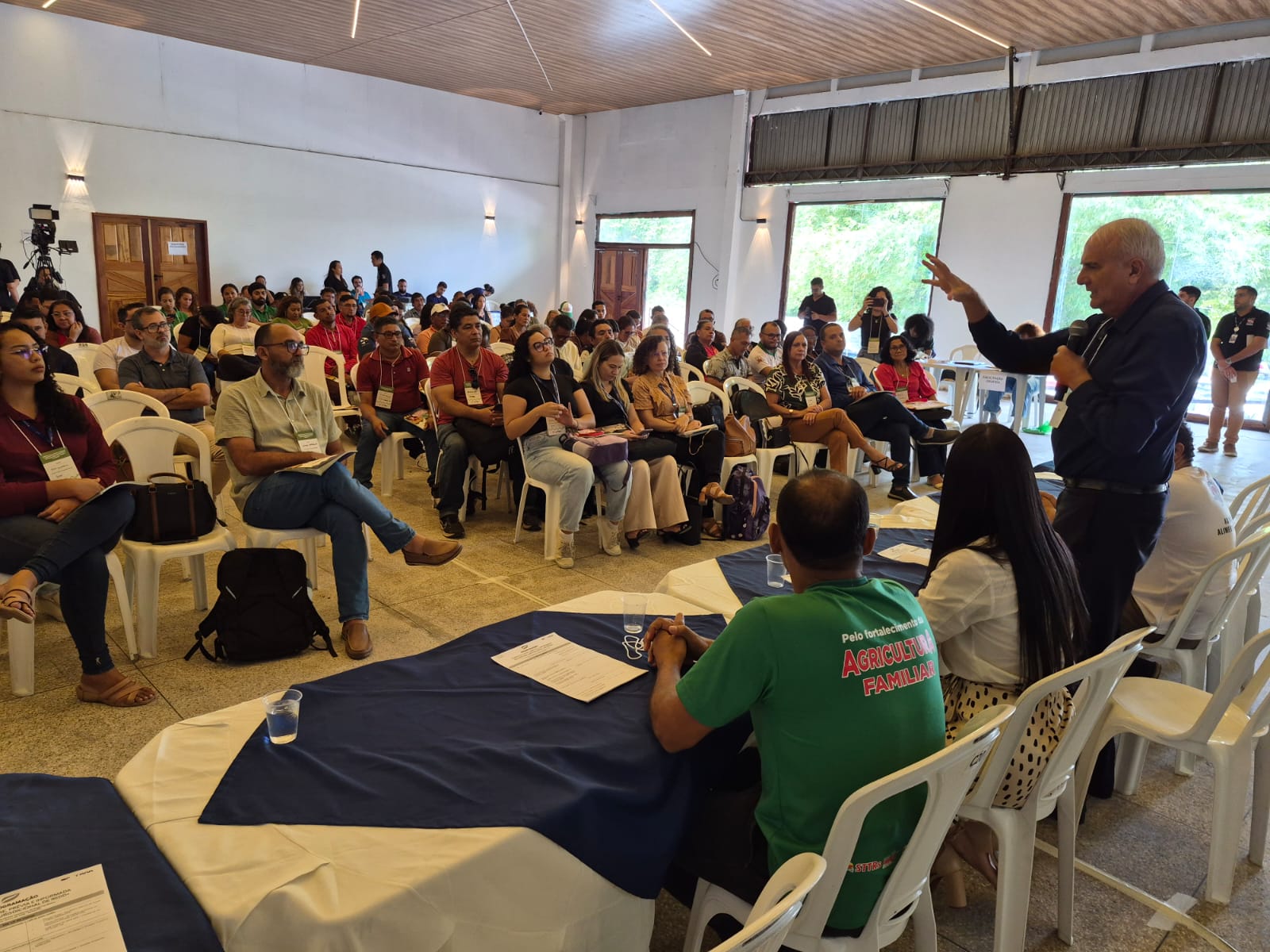 Imagem mostra auditóorio lotafo com homem falando à frente