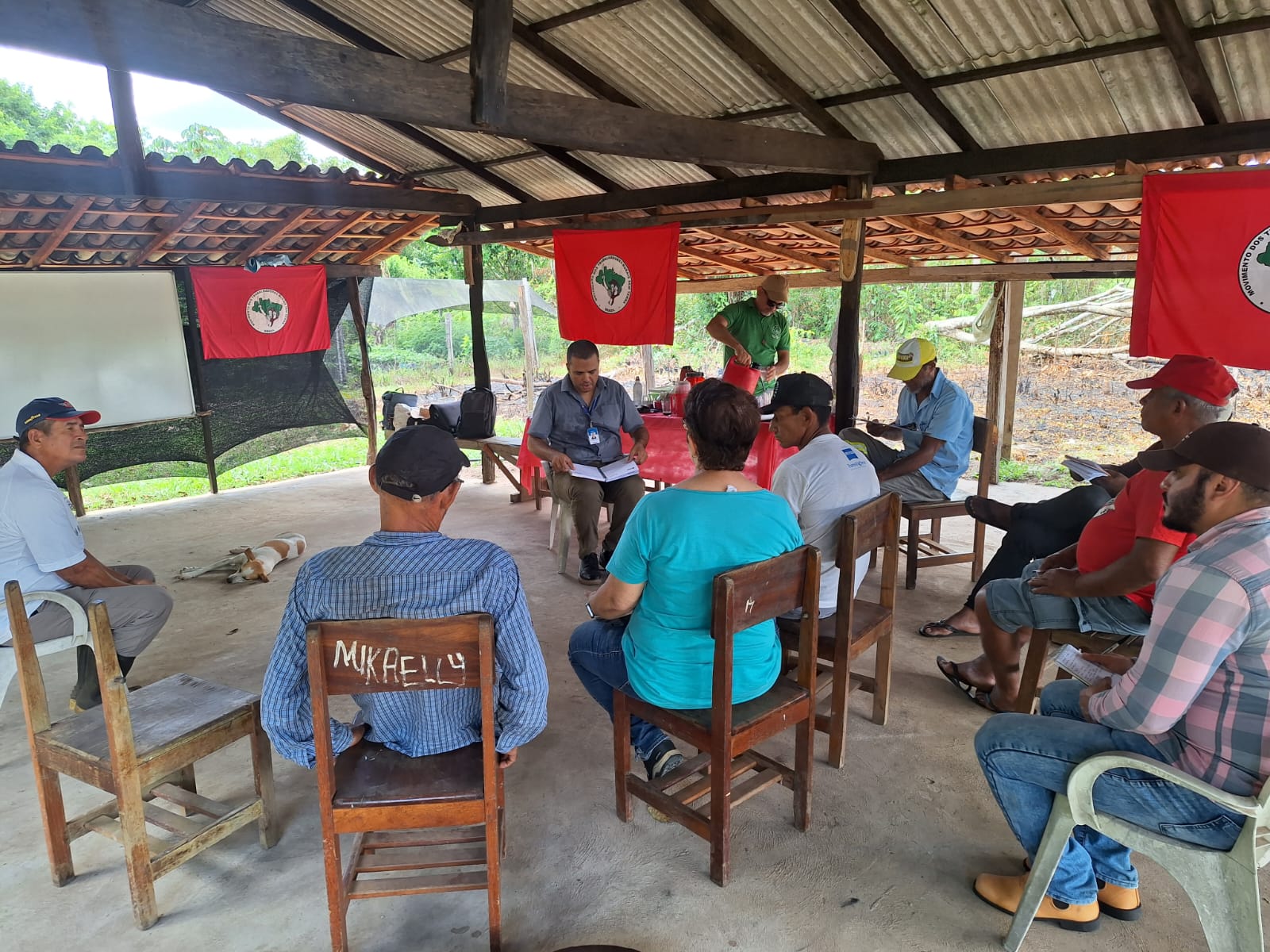 Galpão tem dez pessoas sentadas em atividade de orientação sobre pecuária sustentável