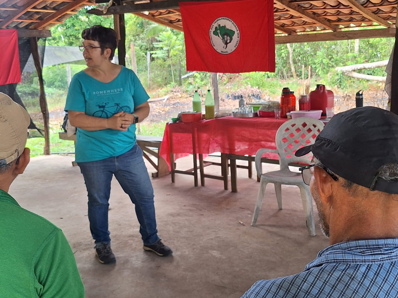 Professora orienta agricultores em barracão de assentamento
