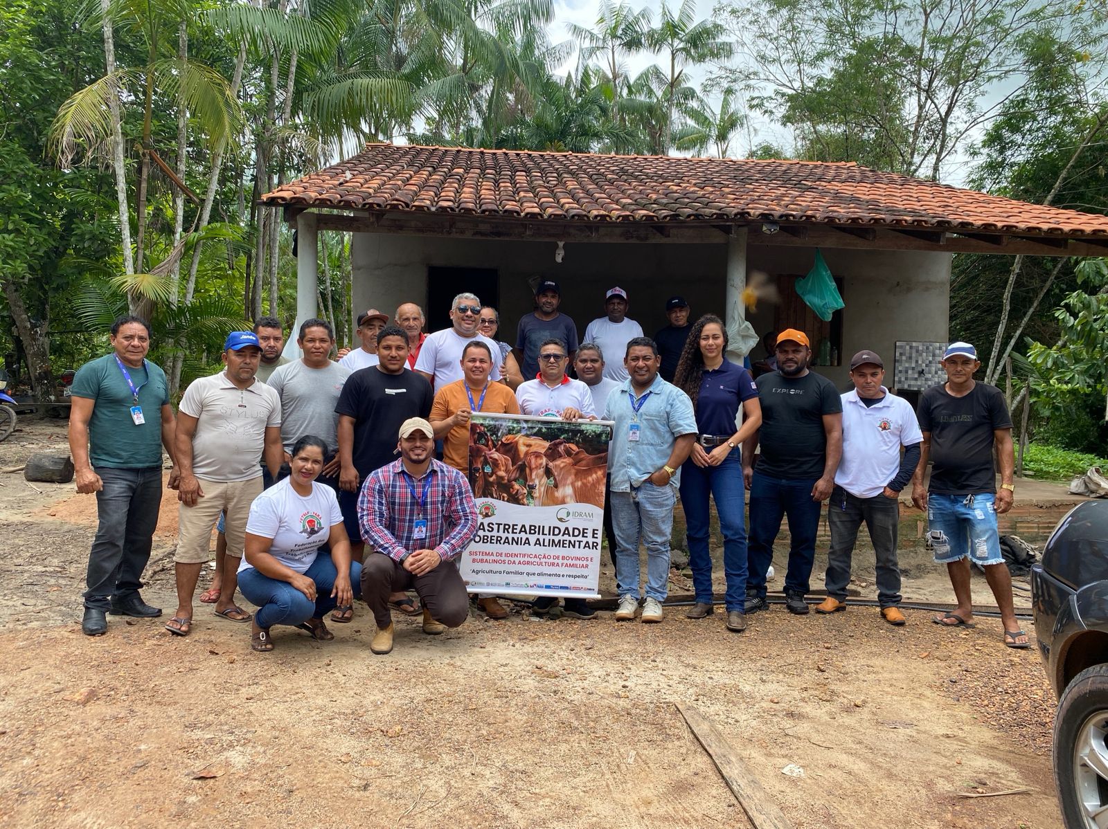imagem mostra grupo de pessoas posando para foto, duas delas com cartaz nas mãos