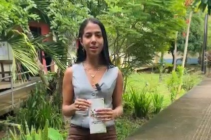 Imagem mostra mulher parda, cabelos lisos, magra, jovem, camisa cinza